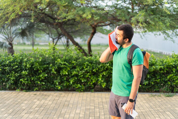 Athlete wiping sweat with towel after exercising outdoors