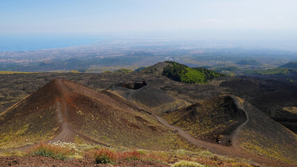 Aerial view of Mount Etna volcanic crater with vivid red and black lava rocks. View of black...