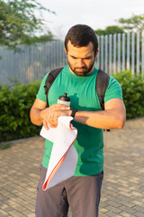 Sportsman checking time during fitness workout outdoors
