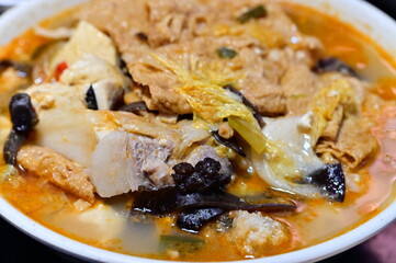 Lin Congming's famous clay pot fish head from Chiayi, Taiwan. Rich milky broth with vegetables, tofu, and golden fried fish in traditional clay pot.