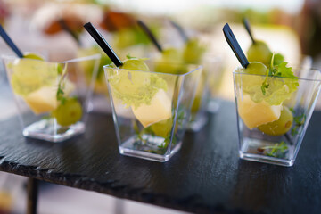 Colorful fruit cups served at a summer outdoor gathering showcasing fresh ingredients and vibrant...