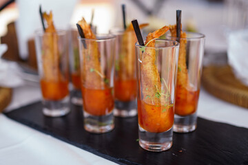 Creative cocktail appetizers with shrimp garnished on a black serving tray at a festive event