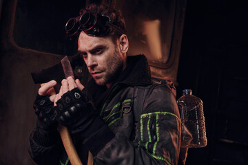Handsome young man inspects his weapon while navigating a desolate and dangerous environment.