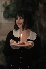 birthday cake with one candle, a girl makes a wish on her birthday