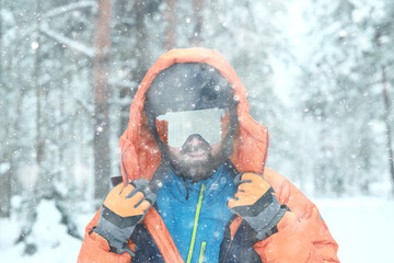 Man in ski helmet and glasses, snowfall extreme sports portrait close-up bearded cheerful