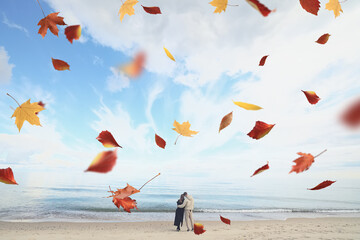 the romance of autumn, a couple in love against the background of autumn leaves and the sky on the seashore