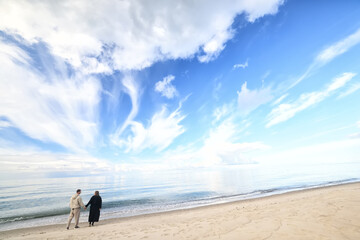 man and woman, couple in love on the seashore spring or autumn view seasonal photo in warm clothes