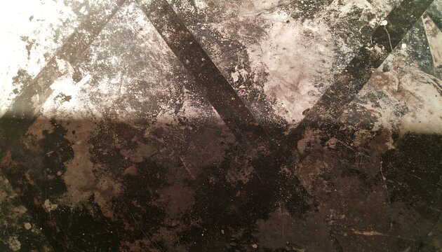 A textured surface of dark grey and light grey hues, exhibiting a pattern of intersecting lines and various spots of discoloration.