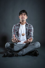 Mind Over Matter. A young Indian man with closed eyes concentrating on levitating an egg while...