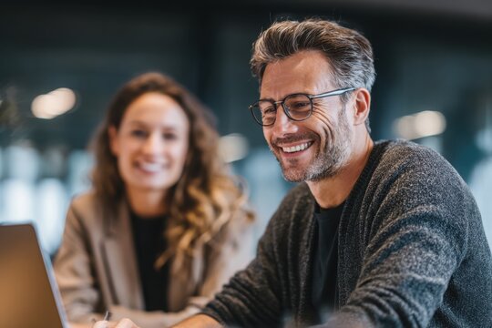 Young business man and woman working together in an office, having fun while looking at a computer screen with happy gestures on their hands. the smiling female appears surprised.