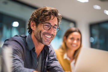 Young business man and woman working together in an office, having fun while looking at a computer screen with happy gestures on their hands. the smiling female appears surprised.