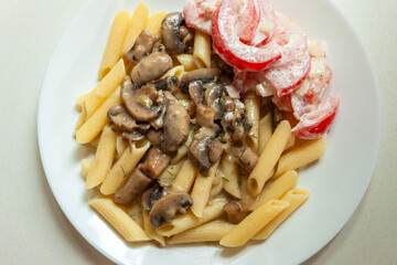 Fried mushrooms with pasta and tomatoes, top view
