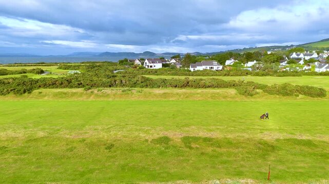 Golfers Walking Across Lush Scottish Highlands Fairway