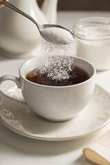 Pouring spoon of sweetener in cup of tea. Sugar alternative, food and nutrition