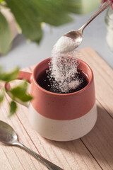 Pouring sweetener powder in cup of tea. Sugar alternative, food and nutrition