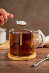 Pouring sweetener powder in cup of tea. Sugar alternative, food and nutrition