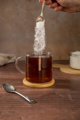 Pouring sweetener powder in cup of tea. Sugar alternative, food and nutrition