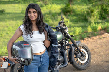 Strong independent Indian woman biker: beautiful girl, stylish rider, motorcycle adventure, elegant jacket, confident posture, powerful machine, free spirit, road journey, fearless attitude.