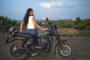 Fototapeta premium Strong independent Indian woman biker: beautiful girl, stylish rider, motorcycle adventure, elegant jacket, confident posture, powerful machine, free spirit, road journey, fearless attitude.