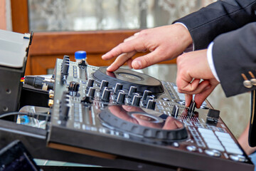 A person operating a DJ mixing console