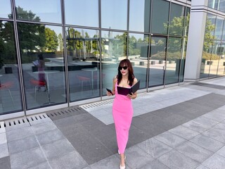 Smiling executive woman with sunglasses and documents