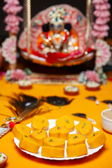Yellow Peda Mithai Offering with Krishna Idol for Janmashtami