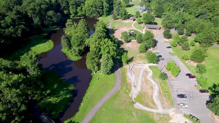 Aerial footage of Boyle Park in Little Rock Arkansas. Camera flies over one of the ponds inside the park. You can see the parking lot and a playground as well.