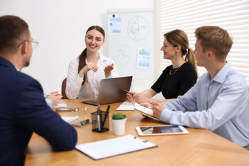 Business coach giving presentation to group of people in office