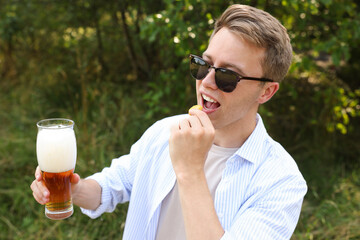 Fototapeta premium Handsome young man with glass of beer outdoors