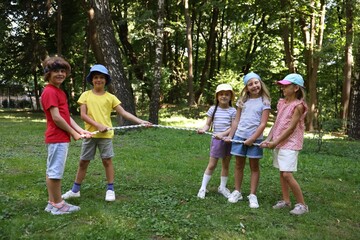 Obraz premium Cute little kids playing tug of war in park