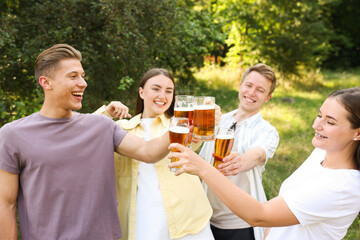 Group of happy friends clinking glasses of beer outdoors