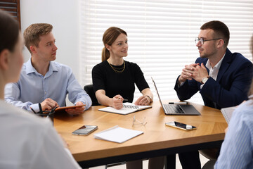 Business coach working with group of people in office