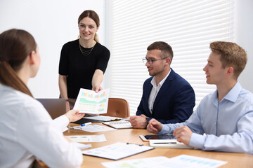 Business coach giving presentation to group of people in office