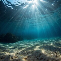 Sunlight streams through the oceans surface, illuminating the sandy bottom and creating a mesmerizing underwater scene with rocks