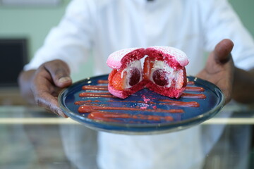A man presents a nice and delicious macaron. Fontenay-sous-Bois, France - April 30, 2025.