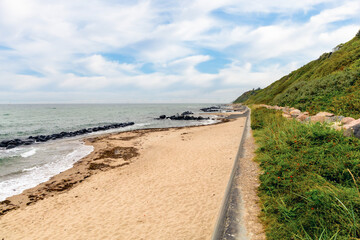 The long coastline stretches with yellow sand beside the blue sea.