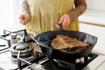 Cooking T-bone steak in cast iron pan