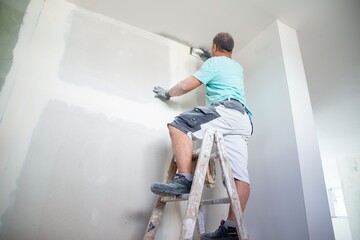 Maler bei Innenarbeiten im Neubau