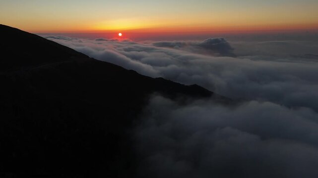 Aerial view of Kocduzu Highland in the Black Sea region of Turkiye, with clouds flowing over the mountain peaks during sunrise