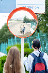 Road mirror, spherical observation at the intersection, reflection of children in the mirror
