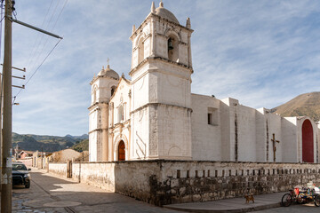 Fototapeta premium Kirche von Sibayo im Colca-Tal, Peru unter blauem Himmel mit weißen Wolken, traditionelle Architektur, historisches Gebäude, Andenlandschaft
