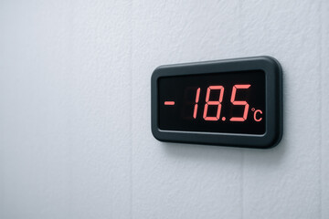 Digital wall thermometer showing minus 185 degrees celsius temperature on modern freezer surface in cold storage environment