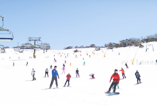 Ski slope at Perisher with skiers and boarders and chair lift