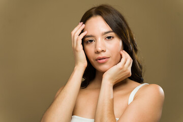 Pretty woman touching face showing perfect skin in studio shot