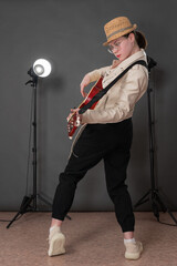 Full length dynamic woman guitarist plays an acoustic guitar and looks directly at camera. Side...