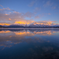 Fototapeta premium Majestic panoramic view of high snow-capped mountains at sunrise