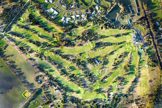 Aerial view of a country golf course bathed in late afternoon light.