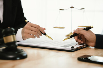 A professional lawyer discusses legal contracts with a client in an office, focusing on justice,...