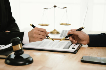 A professional lawyer discusses legal contracts with a client in an office, focusing on justice,...