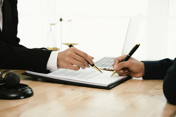 A professional lawyer discusses legal contracts with a client in an office, focusing on justice,...